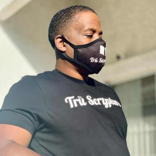 The model is wearing a black Trü Scrypture Signature Tee in an XL.