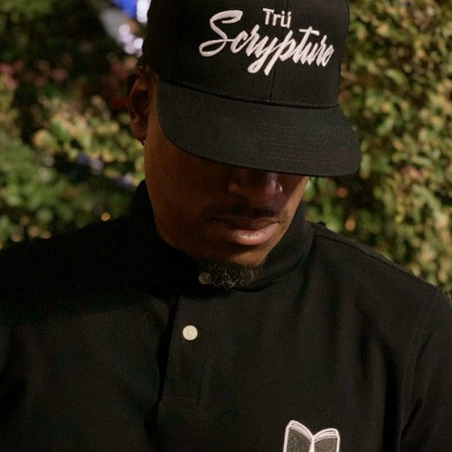 The model is wearing the black snapback cap with 3D embroidered "Trü Scrypture" on the front in a bold yet scripted font.
