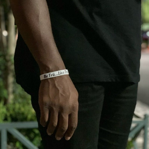 Model wearing the white wristband that features the slogan Be Trü...Live Trü.
